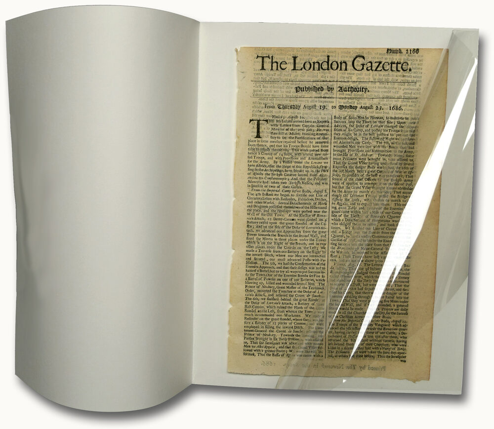 Protective archival folder with clear Mylar film over a newspaper.